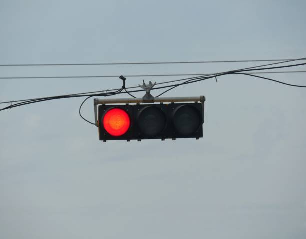 istock Old-fashioned traffic lights on Stop hanging by wires at an intersection 1204113631