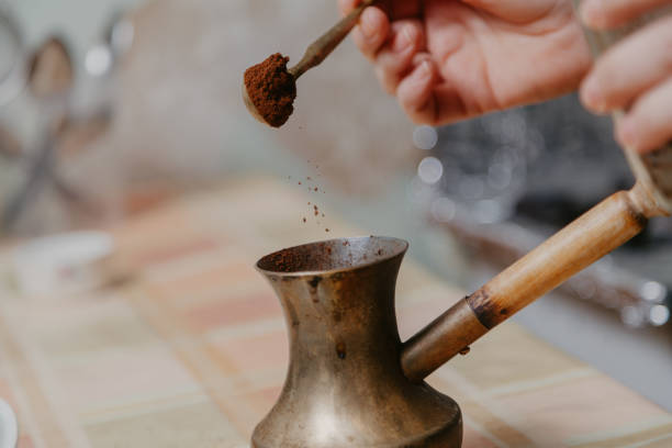 istock Hand pours ground coffee into cezve closeup 1204115164