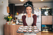 Confectioner woman holding a tray of cupcakes