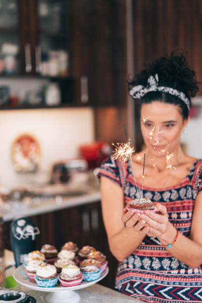 istock Confectioner holding birthday cupcakes 1204116633