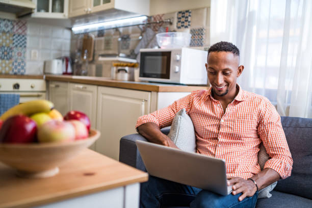 Afro latino men working on a laptop at home Afro latino men working on a laptop at home afro latinx ethnicity stock pictures, royalty-free photos & images