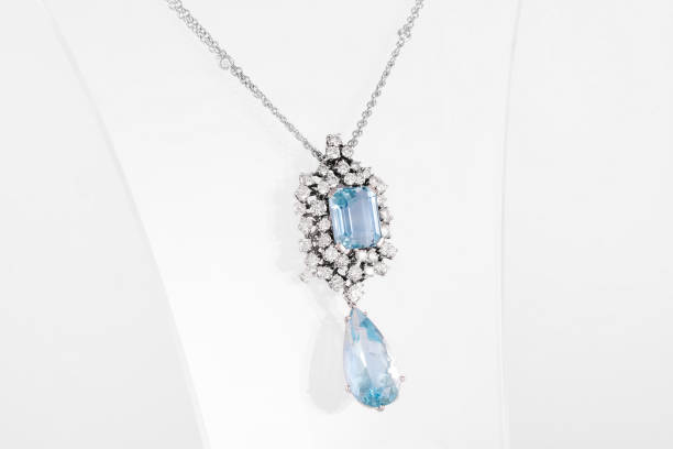 istock Luxury white golden pendant with blue gemstone and diamonds on stand. 1204117640