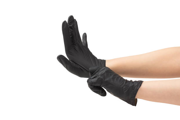 istock Woman puts on black rubber gloves. 1204119273