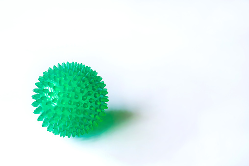 Close up 0f a green color rubber spike ball against white background