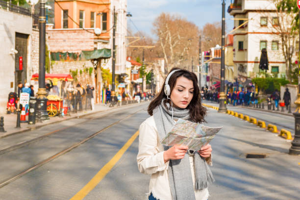 Cute girl explores streets of city with map stock photo