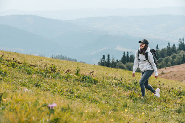 istock woman with backpack hiking in mountains 1204123028