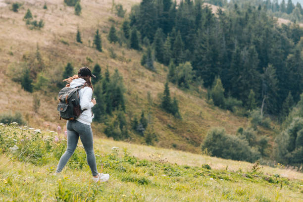 istock woman with backpack hiking in mountains 1204123054