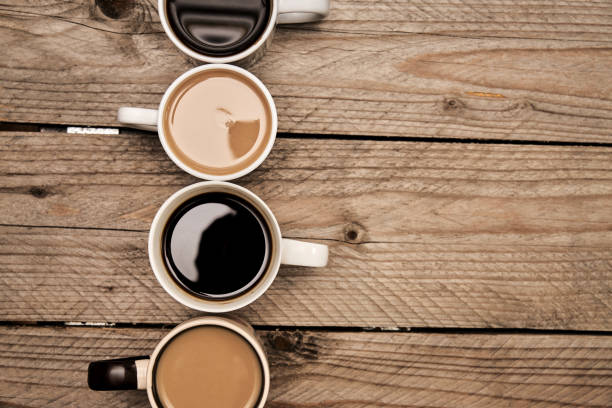 istock Many cups with tasty aromatic coffee  on wooden table. Top view with copy space 1204123322