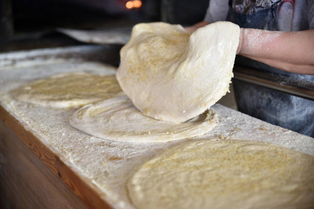 istock Pastry dough covered with sesame. Bakery owner burns bread in a kiln. 1204126737