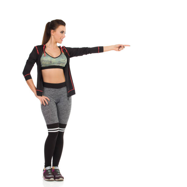 istock Fit Young Woman Is Pointing And Looking Away 1204129615