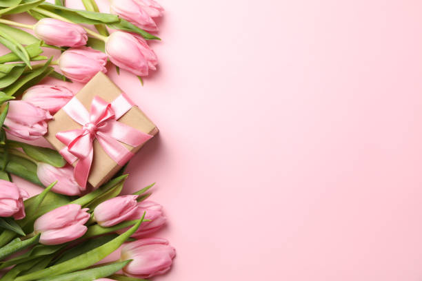 istock Beautiful tulips and gift box on pink background, top view 1204133871