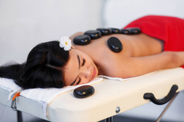 istock Woman lying on massage table with stones on her back at spa 1204135245