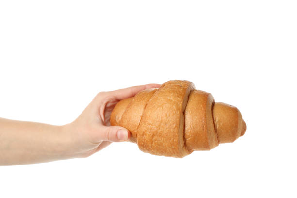 istock Female hand holding croissant, isolated on white background 1204137777