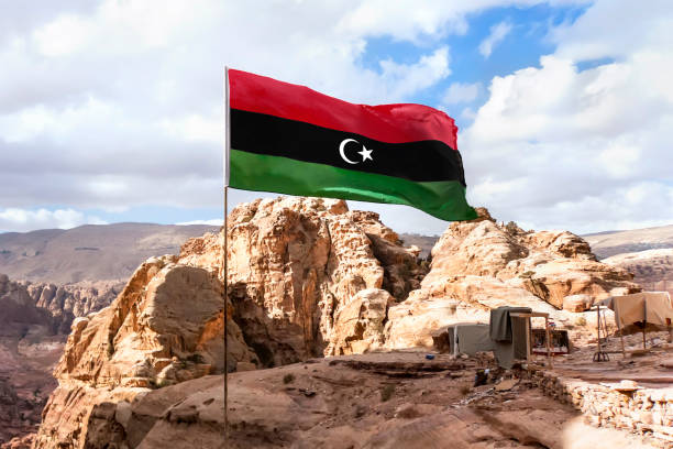 indicateur de la république islamique de libye agitant dans l’arrière-plan de montagne - libyan flag photos et images de collection