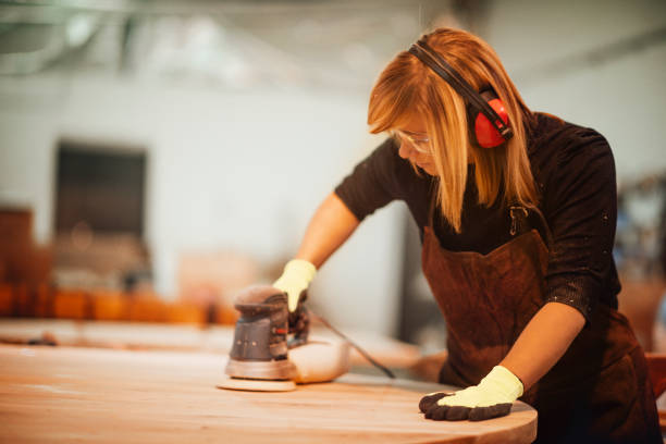 istock Female woodworker using a random-orbit sander to sand a wooden surface 1204142762