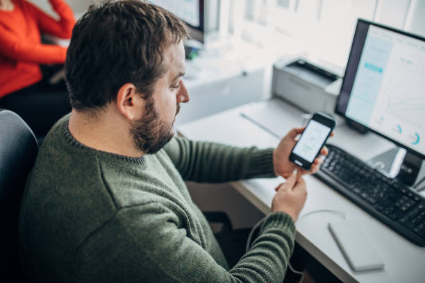 istock Young man working in the office and using power bank 1204144527