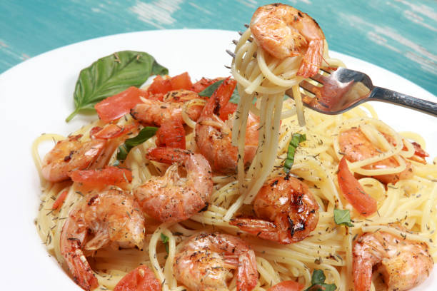 fried prawns or shrimps on a bed of durum wheat spaghetti pasta - prepared shrimp prawn seafood salad imagens e fotografias de stock