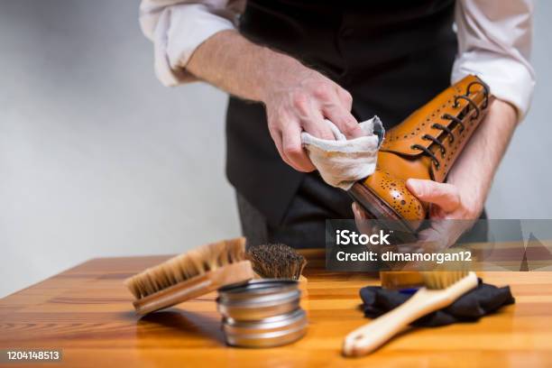 Footwear Concepts And Ideas Closeup Of Hands Of Man Cleaning Premium Derby Boots With Variety Of Brushes And Accessorieshorizontal Image Stock Photo - Download Image Now