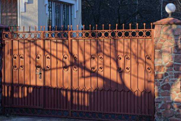 istock one big closed red metal gate with a forged pattern on a rural street 1204149018