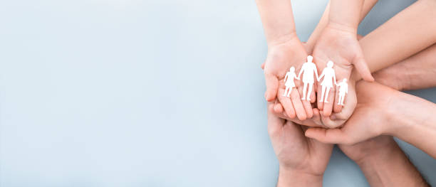 family care concept. hands with paper silhouette on table. - medical concept imagens e fotografias de stock