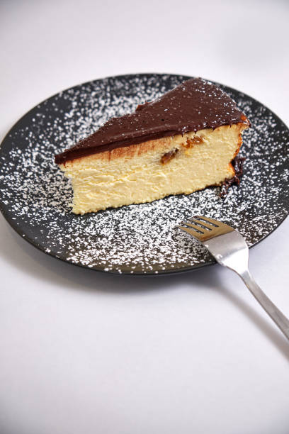 istock Dessert of chocolate cheesecake sprinkled with icing sugar  on a light background 1204149574