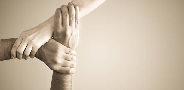 istock Top view of holding hands. Concept of unity, teamwork and support. 1204150428