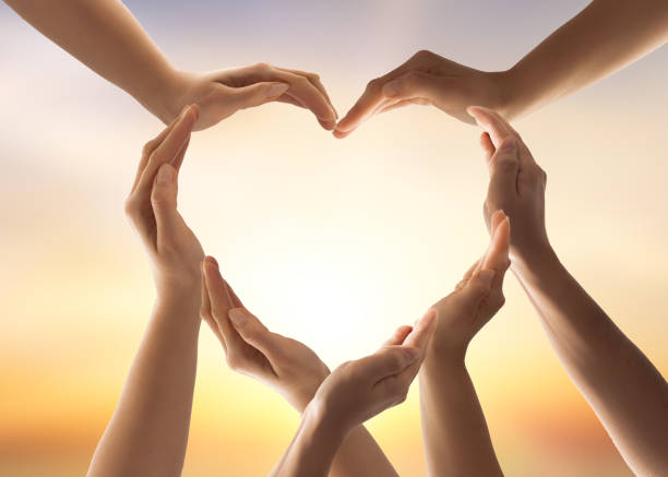 The concept of unity, cooperation, teamwork and charity. Symbol and shape of heart created from hands.The concept of unity, cooperation, partnership, teamwork and charity. hands forming heart shape stock pictures, royalty-free photos & images