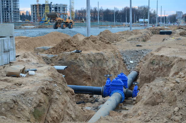 Construction of main water supply pipeline. Laying underground storm sewers at construction site, water main, sanitary sewer, drain systems. Construction of main water supply pipeline. Laying underground storm sewers at construction site, water main, sanitary sewer, drain systems. Installation of the gate valves for city groundwater system underground pipeline stock pictures, royalty-free photos & images