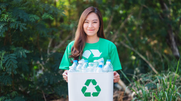 istock woman collecting garbage and holding a recycle bin with plastic bottles 1204152886