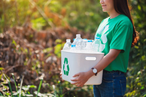 istock woman collecting garbage and holding a recycle bin with plastic bottles 1204153061