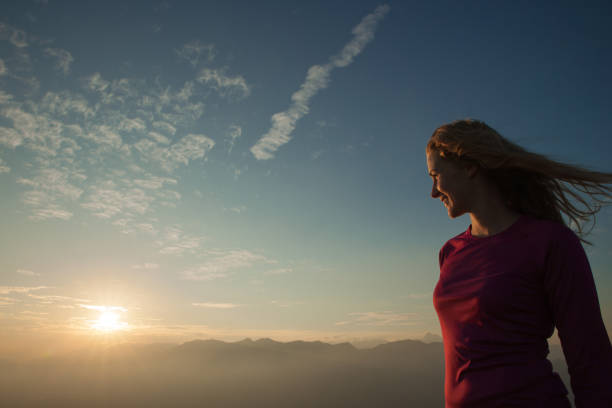 istock Woamn stands on a peak of mountain at sunset 1204153090