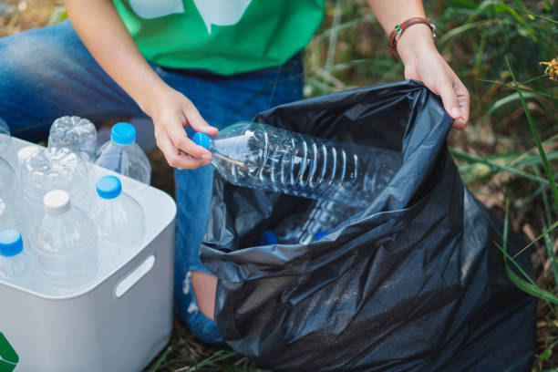 istock A woman picking up garbage plastic bottles into a box and bag 1204153093