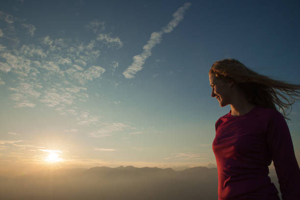 istock Woamn stands on a peak of mountain at sunset 1204153225
