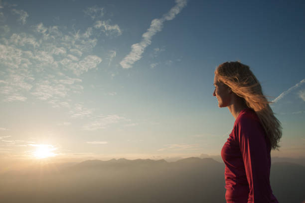 istock Woamn stands on a peak of mountain at sunset 1204153512