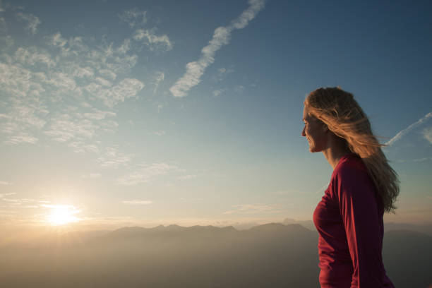 istock Woamn stands on a peak of mountain at sunset 1204153608
