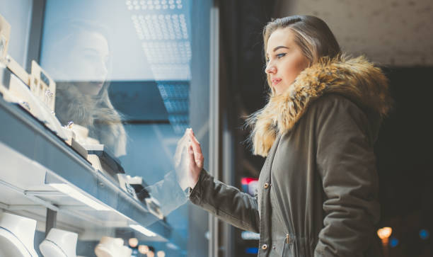 istock Woman window shopping at night 1204154115
