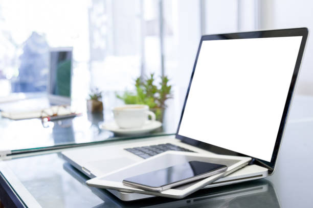 laptop computer with blank white screen and digital tablet on table stock photo