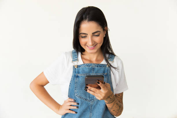 istock Smiling young woman using smartphone 1204157083