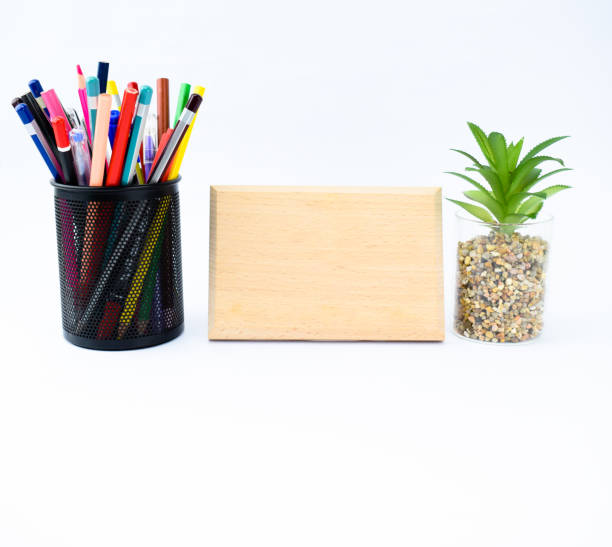 istock A empty wood plaque template along side a miniature tree and pencil holder full of different colored pencils 1204158990