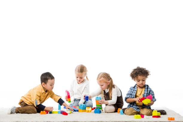 мультикультурных детей, играющих с деревянными блоками на ковре, изолированных на белом - children only isolated isolated on white white стоковые фото и изображения