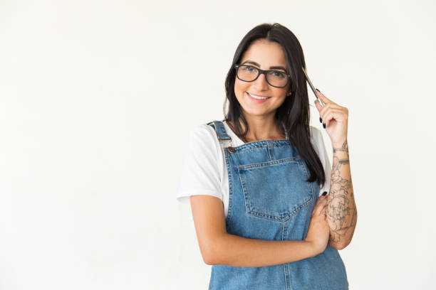 istock Female student holding pen and smiling at camera 1204160172