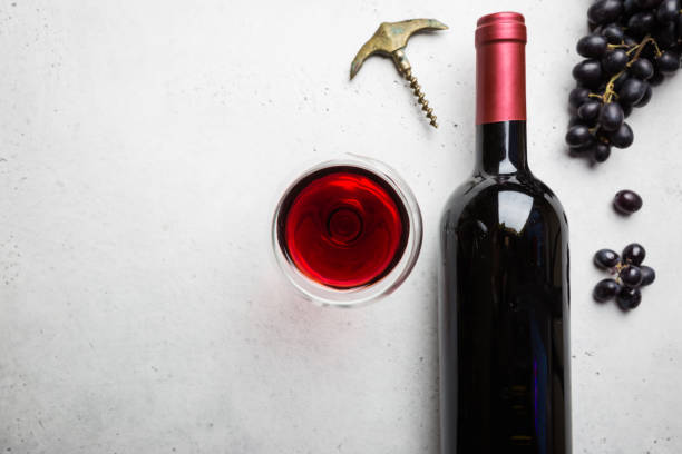 Red wine and ripe grapes Red wine in a glass and ripe grapes on white background, top view maroon photos stock pictures, royalty-free photos & images