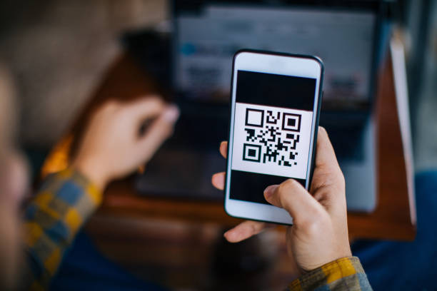 istock Scanning QR code forn laptop using mobile smartphone 1204162511