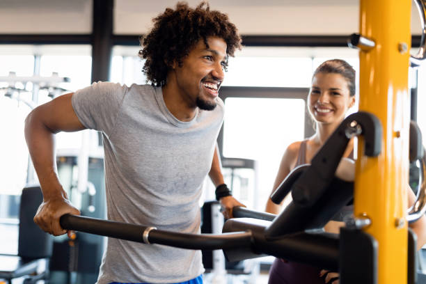 istock Teamwork in gym. Couple working exercise together. 1204163335