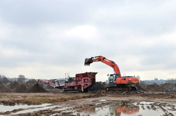istock Mobile jaw stone crusher and heavy excavator working at the construction site 1204163704