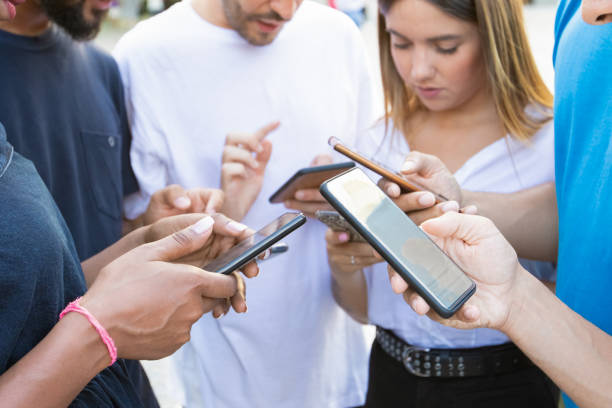 istock Young people using smartphones while standing on street 1204163806