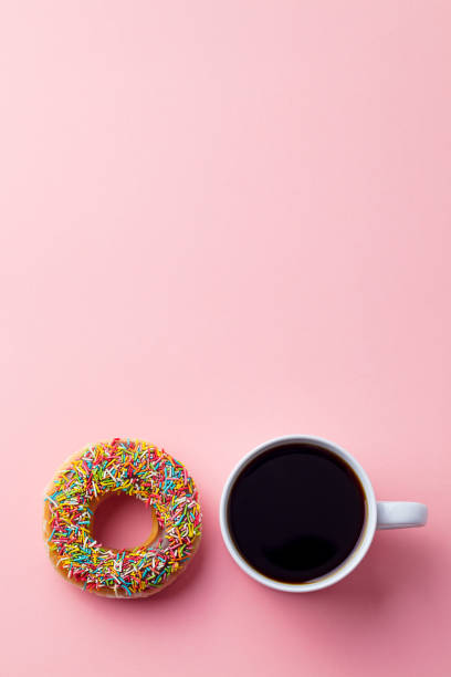 istock Coffee with donut on pink paper background. Top view. Copy space. 1204163960