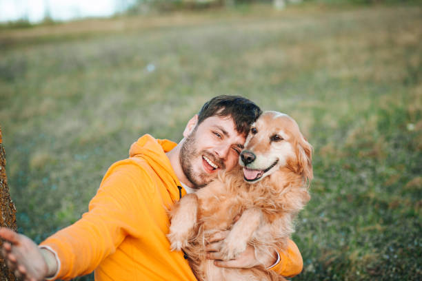 istock Guy and his dog, golden retriever, nature 1204164167