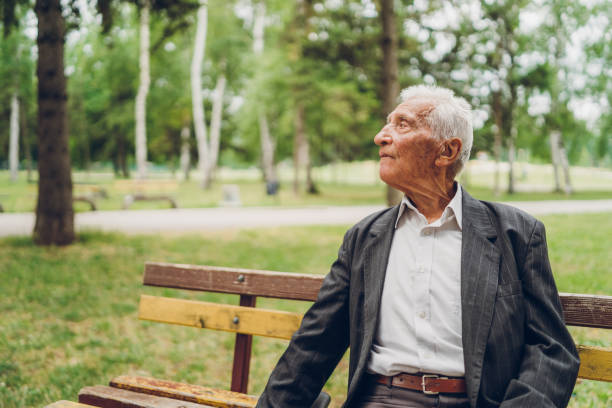 istock Senior man sitting on a park bench 1204164190