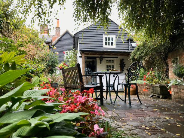 An English cottage garden through the seasons Amersham, UK - 2019: A cottage garden in Autumn. The picture is taken in September and features a garden in the rain amersham stock pictures, royalty-free photos & images